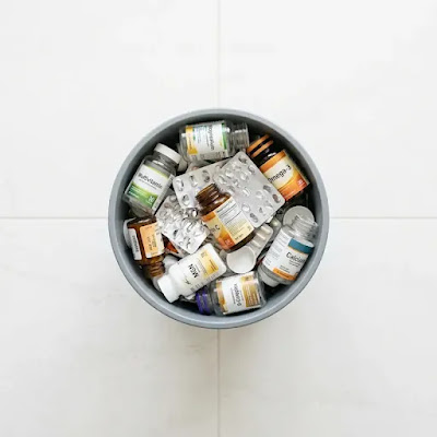 Pile of wasted supplement bottles in a trash bin