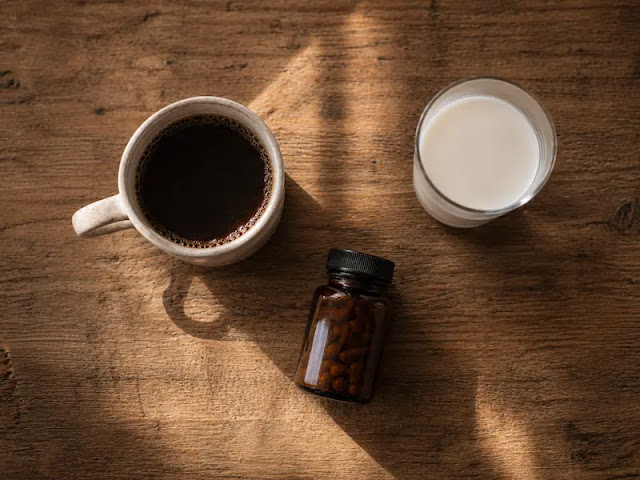 "A coffee cup, glass of milk, and supplement bottle on a wooden table, representing substances that block magnesium absorption."